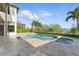 Private pool and spa overlook a tranquil lake, surrounded by lush landscaping and a spacious patio area at 7624 Pointe Venezia Dr, Orlando, FL 32836