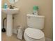 Cozy bathroom featuring a pedestal sink, a toilet and minimal decor at 7644 Fairfax Dr, Kissimmee, FL 34747