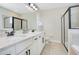 Bright bathroom featuring double sink vanity with granite countertop and glass enclosed shower at 7644 Fairfax Dr, Kissimmee, FL 34747