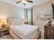 Inviting bedroom with a cozy lamp, a mounted TV, and neutral wall colors at 7644 Fairfax Dr, Kissimmee, FL 34747