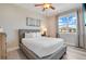 Comfortable bedroom featuring a large window, wood floors, and a ceiling fan at 7644 Fairfax Dr, Kissimmee, FL 34747