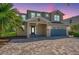 Beautiful two-story home with a two-car garage and a well-manicured brick driveway at 7644 Fairfax Dr, Kissimmee, FL 34747