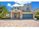 Charming two-story home features a two-car garage and a beautifully paved brick driveway at 7644 Fairfax Dr, Kissimmee, FL 34747