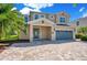 Beautiful two-story home with a two-car garage and a well-manicured brick driveway at 7644 Fairfax Dr, Kissimmee, FL 34747