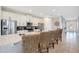 Bright kitchen with white cabinets, stainless appliances, a granite island, and barstool seating at 7644 Fairfax Dr, Kissimmee, FL 34747
