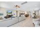 Spacious living area featuring tile flooring, a large sectional couch, and an open floor plan leading to the kitchen at 7644 Fairfax Dr, Kissimmee, FL 34747