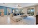 Bright living room with tile floors, a large sectional couch, and sliding glass doors to an outdoor area at 7644 Fairfax Dr, Kissimmee, FL 34747