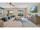 Bright living room with a sectional sofa, TV, and sliding glass doors to the outdoor pool area at 7644 Fairfax Dr, Kissimmee, FL 34747