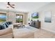 Bright living room with a sectional sofa, TV, and sliding glass doors to the outdoor pool area at 7644 Fairfax Dr, Kissimmee, FL 34747