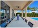 Covered patio and grill alongside the pool with an outdoor dining table at 7644 Fairfax Dr, Kissimmee, FL 34747