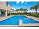 Back view of pool and spa with lounge chairs, outdoor dining and covered patio at 7644 Fairfax Dr, Kissimmee, FL 34747