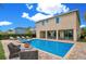 Back view of pool, spa, covered patio, lounge chairs and outdoor seating at 7644 Fairfax Dr, Kissimmee, FL 34747