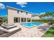 Back exterior view of the pool and spa with lounge chairs and covered patio at 7644 Fairfax Dr, Kissimmee, FL 34747