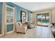 Cozy sitting area with two armchairs, a side table, and sliding door view of pool area at 7644 Fairfax Dr, Kissimmee, FL 34747