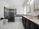 Bathroom featuring a glass-enclosed shower, soaking tub, and double vanity with granite countertops at 826 Jade Forest Ave, Orlando, FL 32828
