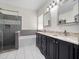 Updated bathroom featuring a glass-enclosed shower, soaking tub, and double vanity with granite countertops at 826 Jade Forest Ave, Orlando, FL 32828
