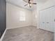 Bright bedroom features wood-look floors, a ceiling fan, a closet with sliding doors and a single window letting in natural light at 826 Jade Forest Ave, Orlando, FL 32828