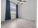 Bedroom features wood-look tile floors, a ceiling fan, and a window with patterned curtains at 826 Jade Forest Ave, Orlando, FL 32828