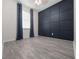 Cozy bedroom features a modern accent wall, large window, and wood-look tile flooring at 826 Jade Forest Ave, Orlando, FL 32828