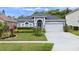 Charming single-story home featuring a manicured lawn, arched entryway, and a two-car garage at 826 Jade Forest Ave, Orlando, FL 32828