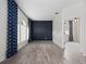 Open-concept living room with wood-look flooring, a dark accent wall, lots of natural light, and an open doorway at 826 Jade Forest Ave, Orlando, FL 32828