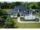 A beautiful gray house with a well-manicured lawn and lovely front garden creates a welcoming curb appeal at 878 Cardinal Pointe Cv, Sanford, FL 32771