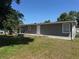 Exterior view of the home showing a deck and sliding glass door, surrounded by green lawn at 9400 Se 119Th St, Belleview, FL 34420