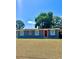 Charming single-story home featuring a well-manicured lawn and a vibrant red front door at 9400 Se 119Th St, Belleview, FL 34420
