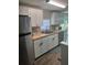 Updated kitchen features stainless steel appliances, white cabinets, and wood countertops at 9400 Se 119Th St, Belleview, FL 34420