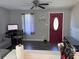 Inviting living room showcasing a red front door, ceiling fan, and modern furnishings at 9400 Se 119Th St, Belleview, FL 34420