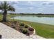 Beautiful backyard with a paver patio, lush landscaping, and serene lake views at 9872 Sw 75Th Street Rd, Ocala, FL 34481