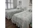 Bedroom features twin beds with coordinated bedding and a view through plantation shutters at 9872 Sw 75Th Street Rd, Ocala, FL 34481