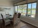 Elegant dining room with large windows offering picturesque lake views and an abundance of natural light at 9872 Sw 75Th Street Rd, Ocala, FL 34481