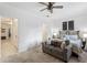 Comfortable main bedroom featuring a queen bed, ceiling fan, and a soft loveseat at 308 Rustic Loop, Sanford, FL 32771