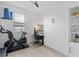 Bright bedroom featuring a modern Murphy bed, Peloton bike, desk, and stylish decor for a functional living space at 308 Rustic Loop, Sanford, FL 32771