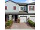 Charming townhome featuring a brick driveway, attached garage, well-maintained landscaping, and neutral-toned exterior at 308 Rustic Loop, Sanford, FL 32771