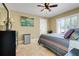 Inviting bedroom with a ceiling fan, plantation shutters, tile floor and a comfortable bed at 32510 Wolf Branch Ln, Sorrento, FL 32776