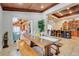 Elegant dining room with rustic wood ceiling, large table and tile flooring; views into kitchen and living spaces at 32510 Wolf Branch Ln, Sorrento, FL 32776