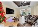 Spacious living room featuring a large TV, coffered wood ceiling, and comfortable leather seating at 32510 Wolf Branch Ln, Sorrento, FL 32776