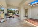 Covered front porch with tile flooring, inviting seating, and natural light streaming through the doorway at 32510 Wolf Branch Ln, Sorrento, FL 32776