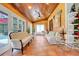 Relaxing sunroom featuring wood ceilings, tile floors, ample seating, and access to the outdoors via glass doors at 32510 Wolf Branch Ln, Sorrento, FL 32776