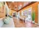Bright sunroom with tile flooring, wood ceiling, comfortable seating, and French doors leading to the exterior at 32510 Wolf Branch Ln, Sorrento, FL 32776