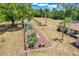 Expansive yard with an array of garden beds and a home with a large grassy area and wooded area at 32510 Wolf Branch Ln, Sorrento, FL 32776