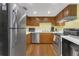 Galley kitchen featuring stainless steel appliances, wood cabinets, and laminate floors at 516 Bahia Cir # B, Ocala, FL 34472