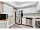 Kitchen with stainless appliances, granite countertops, new white cabinets and grey wood-look floors at 516 Polaris Loop # 110, Casselberry, FL 32707