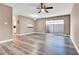Living room with fresh paint, grey wood-look floors, ceiling fan and sliding glass door to lanai at 516 Polaris Loop # 110, Casselberry, FL 32707