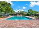 Serene community pool with ample seating surrounded by lush greenery for relaxed lounging at 516 Polaris Loop # 110, Casselberry, FL 32707