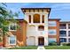 Inviting apartment building featuring a neutral color scheme and well-maintained landscaping at 5512 Metrowest Blvd # 203, Orlando, FL 32811