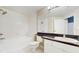 Bright bathroom showcasing a white tiled tub and sink at 5512 Metrowest Blvd # 203, Orlando, FL 32811
