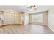 Bright living area boasts wood-look floors, a ceiling fan, and a large window at 5512 Metrowest Blvd # 203, Orlando, FL 32811